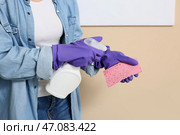 Молодая женщина с бутылкой средства для удаления плесени дома, крупный план. Стоковое фото, фотограф Pixel_shot / Фотобанк Лори