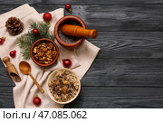 Миски с традиционной украинской кутьей, ветка ели и рождественские шары на черном деревянном фоне. Стоковое фото, фотограф Pixel_shot / Фотобанк Лори