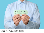 Мужчина с рейтингом улыбается на синем фоне, крупный план. Концепция опроса. Стоковое фото, фотограф Pixel_shot / Фотобанк Лори