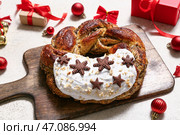 Деревянная доска с вкусным рождественским венком из выпечки, подарочными коробками, декором и печеньем на светлом фоне с эффектом состаривания. Стоковое фото, фотограф Pixel_shot / Фотобанк Лори