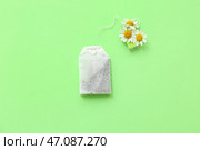 Чайный пакетик с цветками ромашки на зеленом фоне. Вид сверху. Стоковое фото, фотограф Pixel_shot / Фотобанк Лори