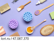 Массажеры для кожи головы с шампунем, миска с медом и морской солью на фоне лилового цвета. Стоковое фото, фотограф Pixel_shot / Фотобанк Лори