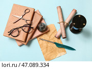 Старая лист бумаги с книгами, перьевой ручкой, чернильницей, свитками и ножницами на синем фоне. Стоковое фото, фотограф Pixel_shot / Фотобанк Лори