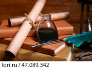 Старые книги с перьевой ручкой, чернильницей и свитками на деревянном фоне. Стоковое фото, фотограф Pixel_shot / Фотобанк Лори