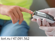 Доктор проверяет уровень сахара в крови мальчика-диабетика, крупным планом. Стоковое фото, фотограф Pixel_shot / Фотобанк Лори