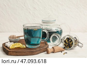 Чашка чая из цветков клитории на деревянном подносе на столе. Стоковое фото, фотограф Pixel_shot / Фотобанк Лори