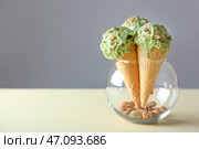 Вафельные рожки с вкусным фисташковым мороженым на столе. Стоковое фото, фотограф Pixel_shot / Фотобанк Лори