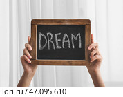 Женские руки со словом МЕЧТА написано на доске. Стоковое фото, фотограф Pixel_shot / Фотобанк Лори