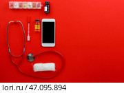 Современный мобильный телефон с врачебными принадлежностями на цветном фоне. Стоковое фото, фотограф Pixel_shot / Фотобанк Лори