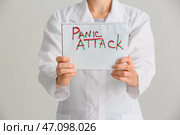 Женщина-врач держит ноутбук с письменным текстом ПАНИЧЕСКАЯ АТАКА на белом фоне, крупным планом. Стоковое фото, фотограф Pixel_shot / Фотобанк Лори