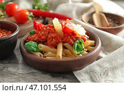Тарелка с вкусной пастой пенне и соусом Болоньезе на деревянном столе. Стоковое фото, фотограф Pixel_shot / Фотобанк Лори