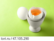 Подставка с треснутыми и цельными куриными яйцами на цветном фоне. Стоковое фото, фотограф Pixel_shot / Фотобанк Лори