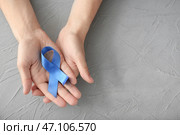 Мужские руки держа голубую ленту на серой предпосылке. Концепция рака простаты. Стоковое фото, фотограф Pixel_shot / Фотобанк Лори