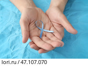 Мужские руки держа голубую ленту на предпосылке цвета. Концепция рака простаты. Стоковое фото, фотограф Pixel_shot / Фотобанк Лори