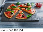 Грифельная тарелка с кусочками вкусной пиццы на деревянном столе. Стоковое фото, фотограф Pixel_shot / Фотобанк Лори