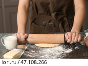 Женщина раскатывает тесто для булочек с корицей за столом. Стоковое фото, фотограф Pixel_shot / Фотобанк Лори