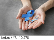 Мужские руки, держа синие ленты на сером фоне. Концепция рака простаты. Стоковое фото, фотограф Pixel_shot / Фотобанк Лори