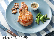 Тарелка с вкусным жареным стейком, гарниром и соусом на столе. Стоковое фото, фотограф Pixel_shot / Фотобанк Лори