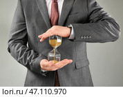 Человек держа часы на серой предпосылке. Концепция тайм-менеджмента. Стоковое фото, фотограф Pixel_shot / Фотобанк Лори