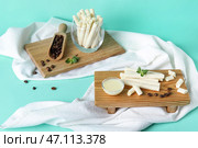 Доски с вкусными вафельными трубочками, кофейными зернами и сгущенкой на бирюзовом фоне. Стоковое фото, фотограф Pixel_shot / Фотобанк Лори