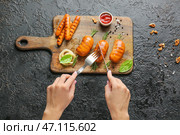 Женщина ест вкусные колбаски гриль с соусом. Стоковое фото, фотограф Pixel_shot / Фотобанк Лори
