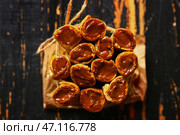 Вкусные вафельные трубочки с вареной сгущенкой на черном деревянном фоне. Стоковое фото, фотограф Pixel_shot / Фотобанк Лори
