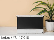 Очиститель воздуха и комнатное растение на столе возле бежевой стены. Стоковое фото, фотограф Pixel_shot / Фотобанк Лори