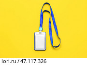 Пустой бейдж с синим шнурком на желтом фоне. Стоковое фото, фотограф Pixel_shot / Фотобанк Лори