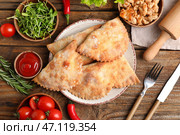 Тарелка с запеченными мясными блинчиками, мясом, овощами, соусом и зеленью на деревянном фоне. Стоковое фото, фотограф Pixel_shot / Фотобанк Лори