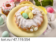 Подставка для десертов с вкусным куличом и крашеными яйцами на светлом деревянном столе, крупным планом. Стоковое фото, фотограф Pixel_shot / Фотобанк Лори