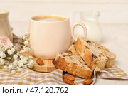 Вкусное печенье бискотти, цветы гипсофилы и чашка кофе на салфетке. Стоковое фото, фотограф Pixel_shot / Фотобанк Лори