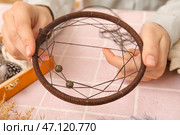 Женщина делает ловец снов на столе из розовой плитки, крупным планом. Стоковое фото, фотограф Pixel_shot / Фотобанк Лори