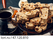 Тарелка с печеньем бискотти и кофе в турке на черном фоне. Стоковое фото, фотограф Pixel_shot / Фотобанк Лори