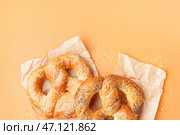 Бумага для выпечки с вкусными кренделями на цветном фоне. Стоковое фото, фотограф Pixel_shot / Фотобанк Лори