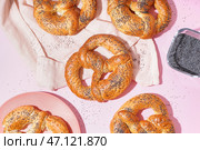 Вкусные крендельки с маком на розовом фоне. Стоковое фото, фотограф Pixel_shot / Фотобанк Лори