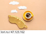 Композиция с чашкой кофе, маской для сна и бумажными облаками на оранжевом фоне. Стоковое фото, фотограф Pixel_shot / Фотобанк Лори