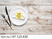 Бумага с текстом HAPPIL FOOLS DAY и сервировкой стола на белом деревянном фоне. Стоковое фото, фотограф Pixel_shot / Фотобанк Лори