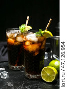 Стаканы холодного коктейля Cuba Libre на темном фоне. Стоковое фото, фотограф Pixel_shot / Фотобанк Лори