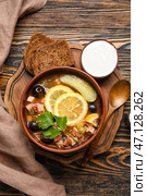 Миска вкусного супа Ходжпож с сметаной и хлебом на деревянном фоне. Стоковое фото, фотограф Pixel_shot / Фотобанк Лори