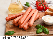 Доска с вкусными колбасами с базиликом и помидорами на столе. Стоковое фото, фотограф Pixel_shot / Фотобанк Лори
