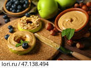Пробковый коврик из вкусных яблочных кружков с ореховым маслом на деревянном столе, крупным планом. Стоковое фото, фотограф Pixel_shot / Фотобанк Лори