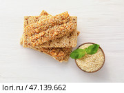 Вкусные батончики козинаки и миска с семенами кунжута на светлом фоне. Стоковое фото, фотограф Pixel_shot / Фотобанк Лори