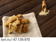 Салфетка с вкусными кунжутными козинаками на темном деревянном фоне, крупным планом. Стоковое фото, фотограф Pixel_shot / Фотобанк Лори