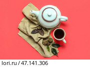 Салфетка с сухим прессованным чаем пуэр, чашка и чайник на красном фоне. Стоковое фото, фотограф Pixel_shot / Фотобанк Лори