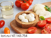 Деревянная миска с вкусным сыром моцарелла и помидорами на столе, крупным планом. Стоковое фото, фотограф Pixel_shot / Фотобанк Лори