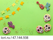Рамка из печенья, флагов и брызг на зеленом фоне. Эль Диа де Муэртос. Стоковое фото, фотограф Pixel_shot / Фотобанк Лори