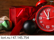 Красный будильник, рождественский подарок и украшения на деревянном фоне, крупным планом. Стоковое фото, фотограф Pixel_shot / Фотобанк Лори