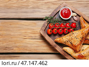 Доска с вкусной узбекской самсой и томатным соусом на деревянном фоне. Стоковое фото, фотограф Pixel_shot / Фотобанк Лори