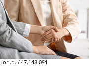 Деловые женщины пожимают друг другу руки во время встречи в офисе. Стоковое фото, фотограф Pixel_shot / Фотобанк Лори