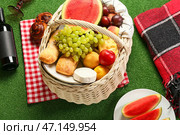 Плетеная корзина с вкусной едой для пикника на зеленом фоне. Стоковое фото, фотограф Pixel_shot / Фотобанк Лори